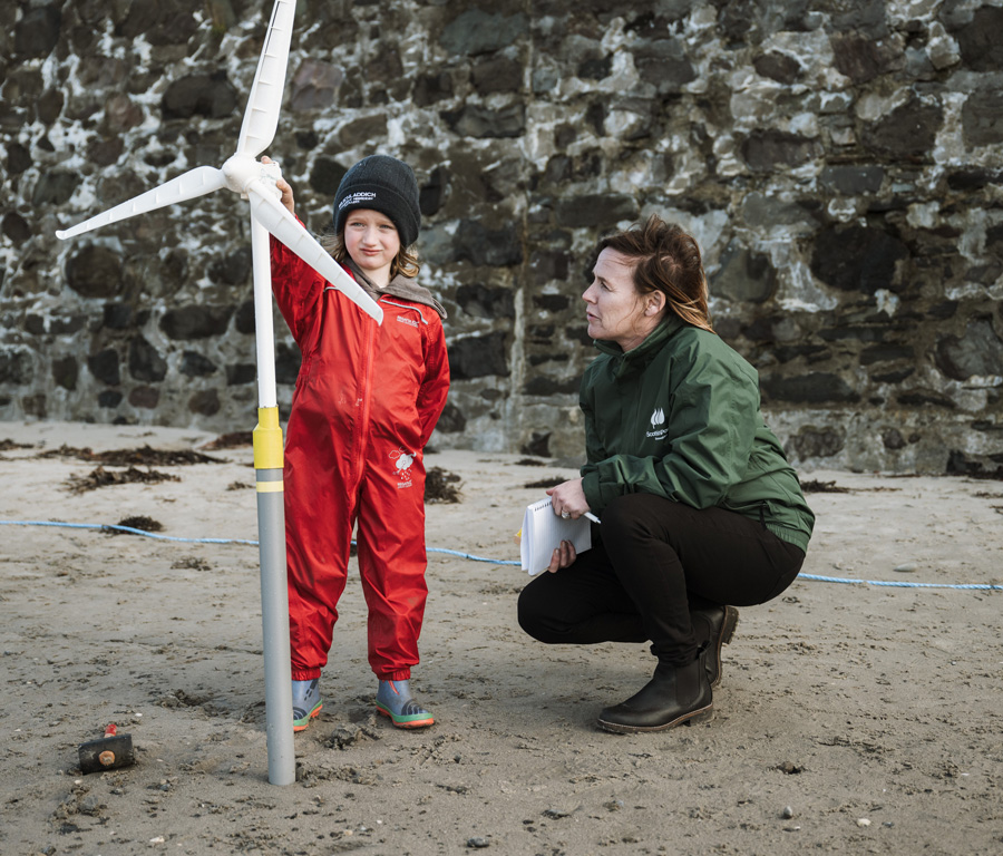 ScottishPower Employee teaches a young child about windmills with prop